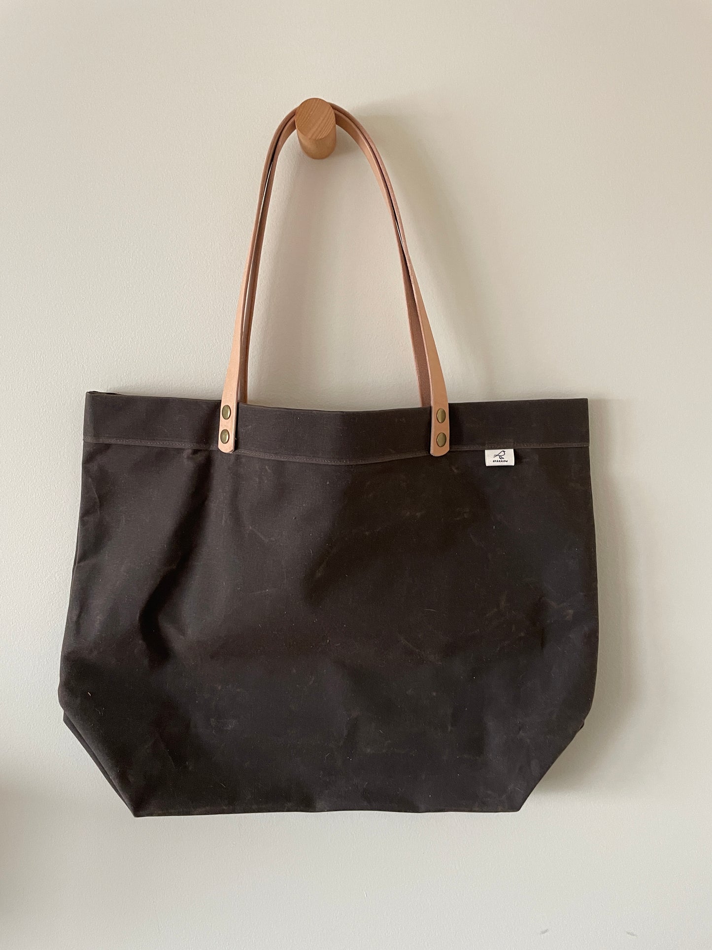 Handmade simple waxed canvas shopping tote with full-grain leather handles, in chocolate brown.