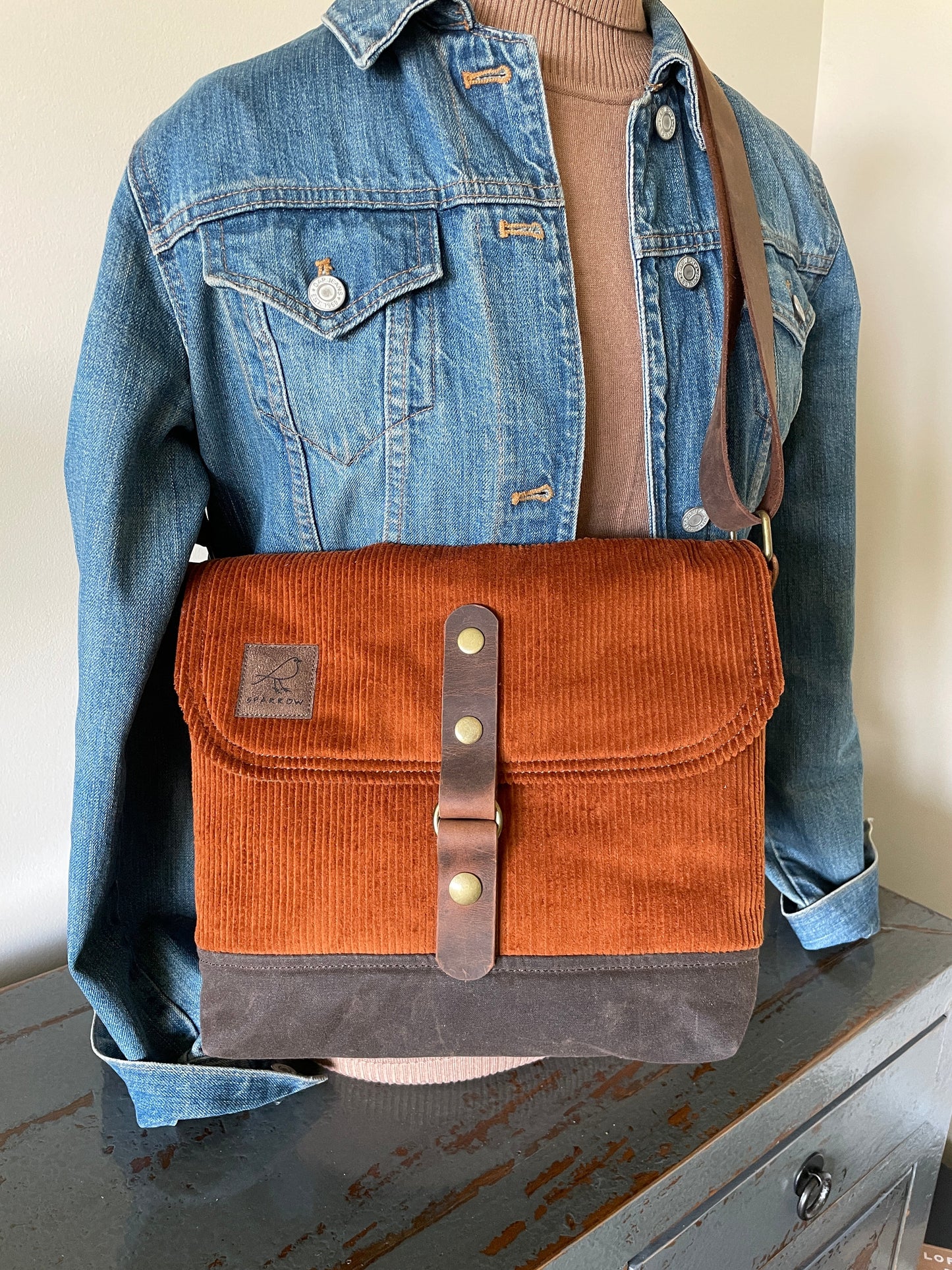 Shortie crossbody messenger bag in burnt orange corduroy,brown waxed canvas base, and full-grain leather strap and accents.