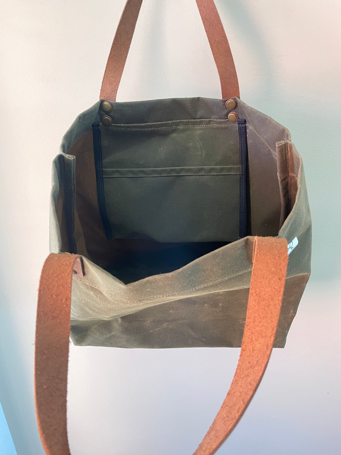 Interior view of Harvest Tote waxed canvas shopping tote, showing slip pocket and key clasp.