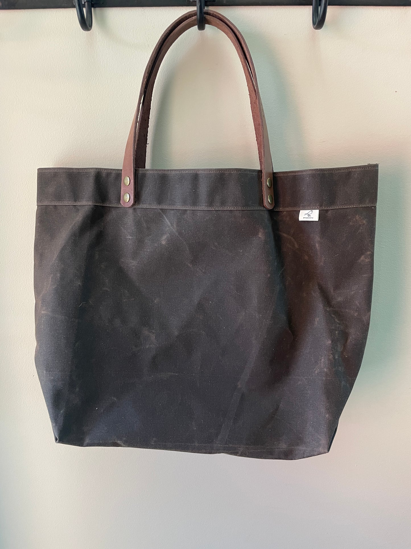 Handmade simple waxed canvas shopping tote with full-grain leather handles, in chocolate brown.