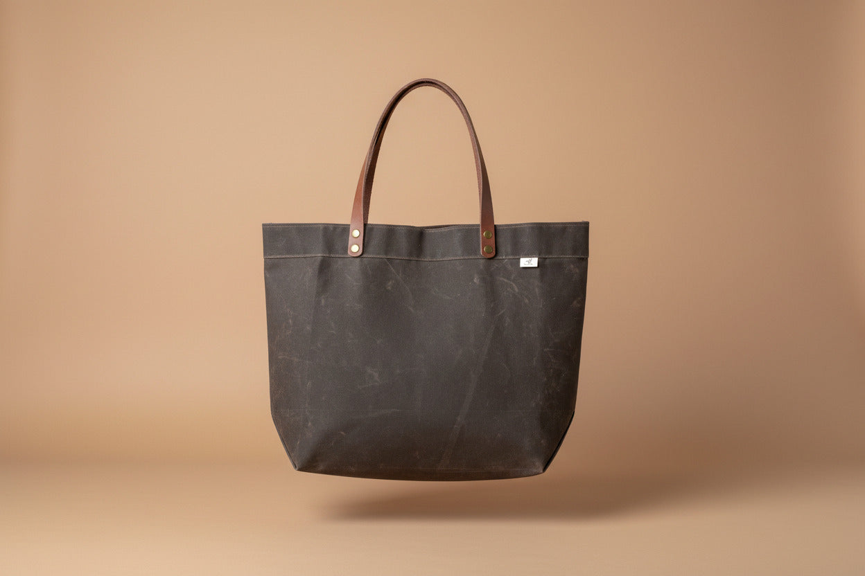 Handmade simple waxed canvas shopping tote with full-grain leather handles, in chocolate brown.