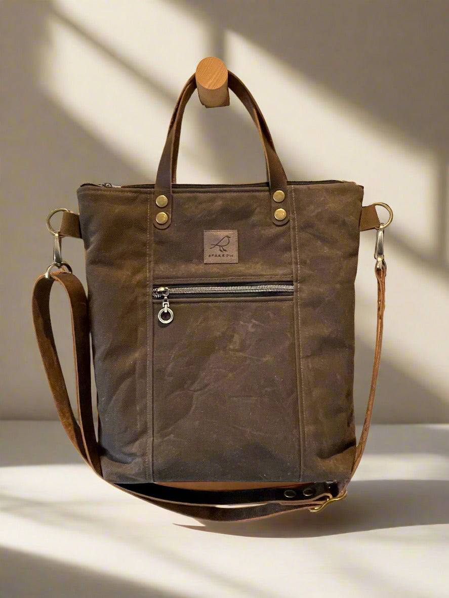Lined crossbody/handbag in waxed canvas with leather handles and adjustable strap. Multiple zippered and slip pockets inside and out. Color choices are tan, chocolate brown, and olive green.