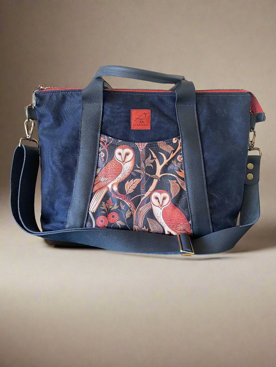 Oxbow crossbody/tote bag in waxed canvas exterior, with leather adjustable strap and handles. Two exterior front pockets, multiple inner pocket, fully lined. Navy waxed canvas, owl print on accent front and back pockets.