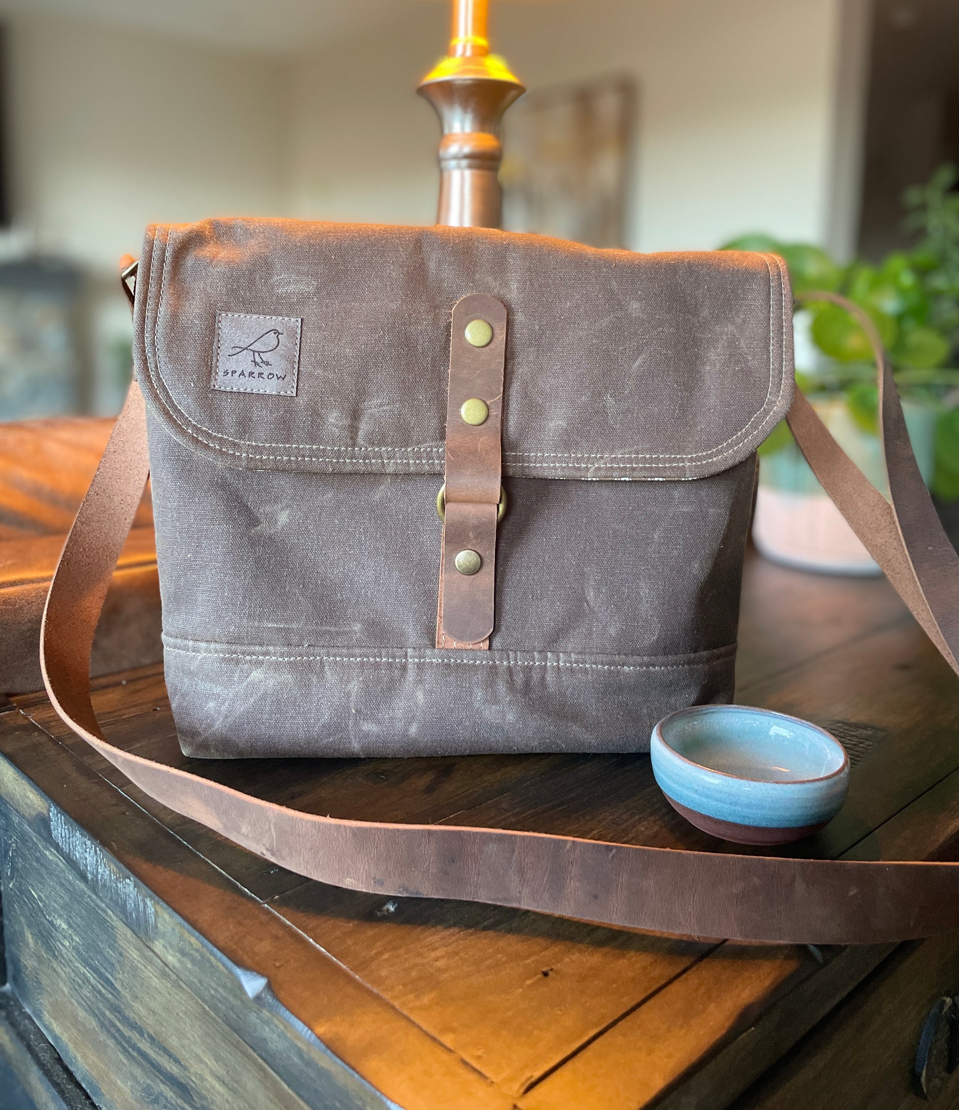 Shortie Messenger bag in chocolate  brown waxed canvas. Brown leather 1.5 inch adjustable strap with a leather snap closure. Unisex bag. 