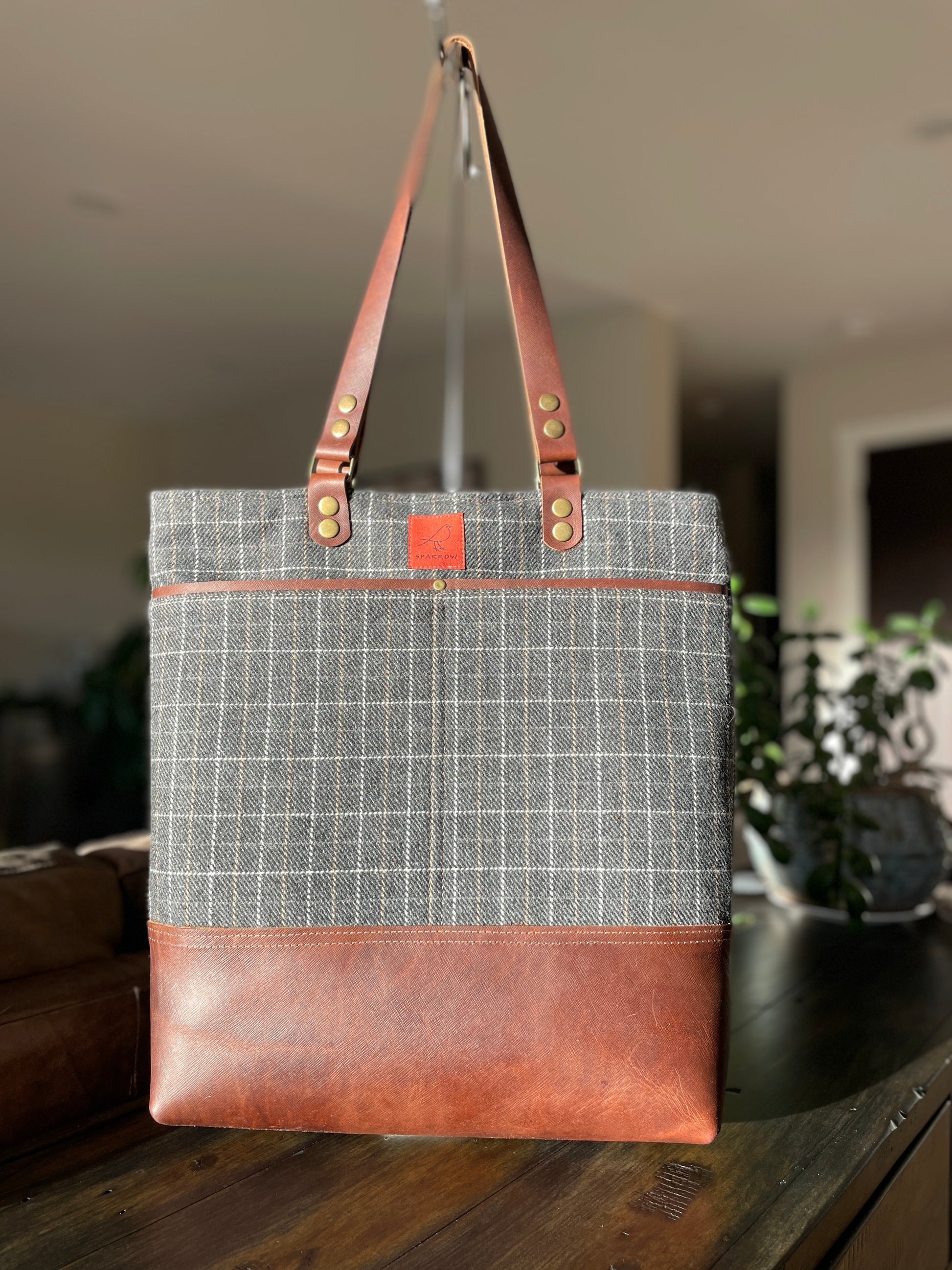 Classic tote bag with grey checkered wool upper, brown leather base and straps. Two front slip pockets, 1 back leather slip pocket, fully lined with slip pockets and zippered pocket inside. Very classic, timeless style. 