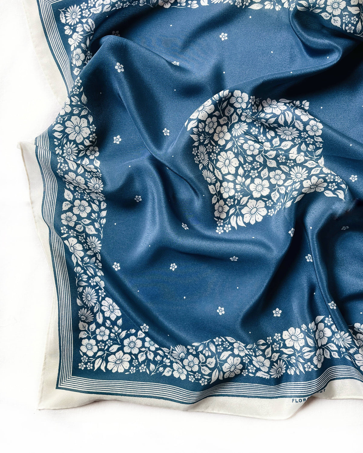 Silk scarf with blue background and white floral pattern