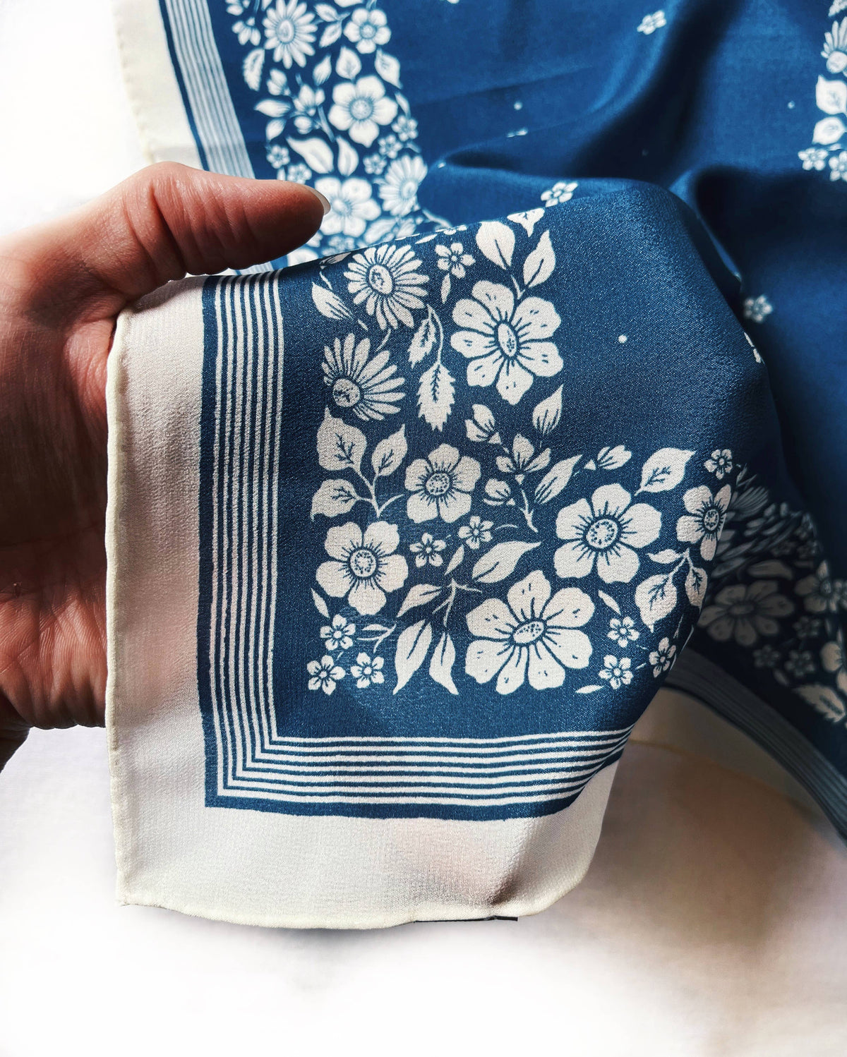 Silk scarf with blue background and white floral pattern