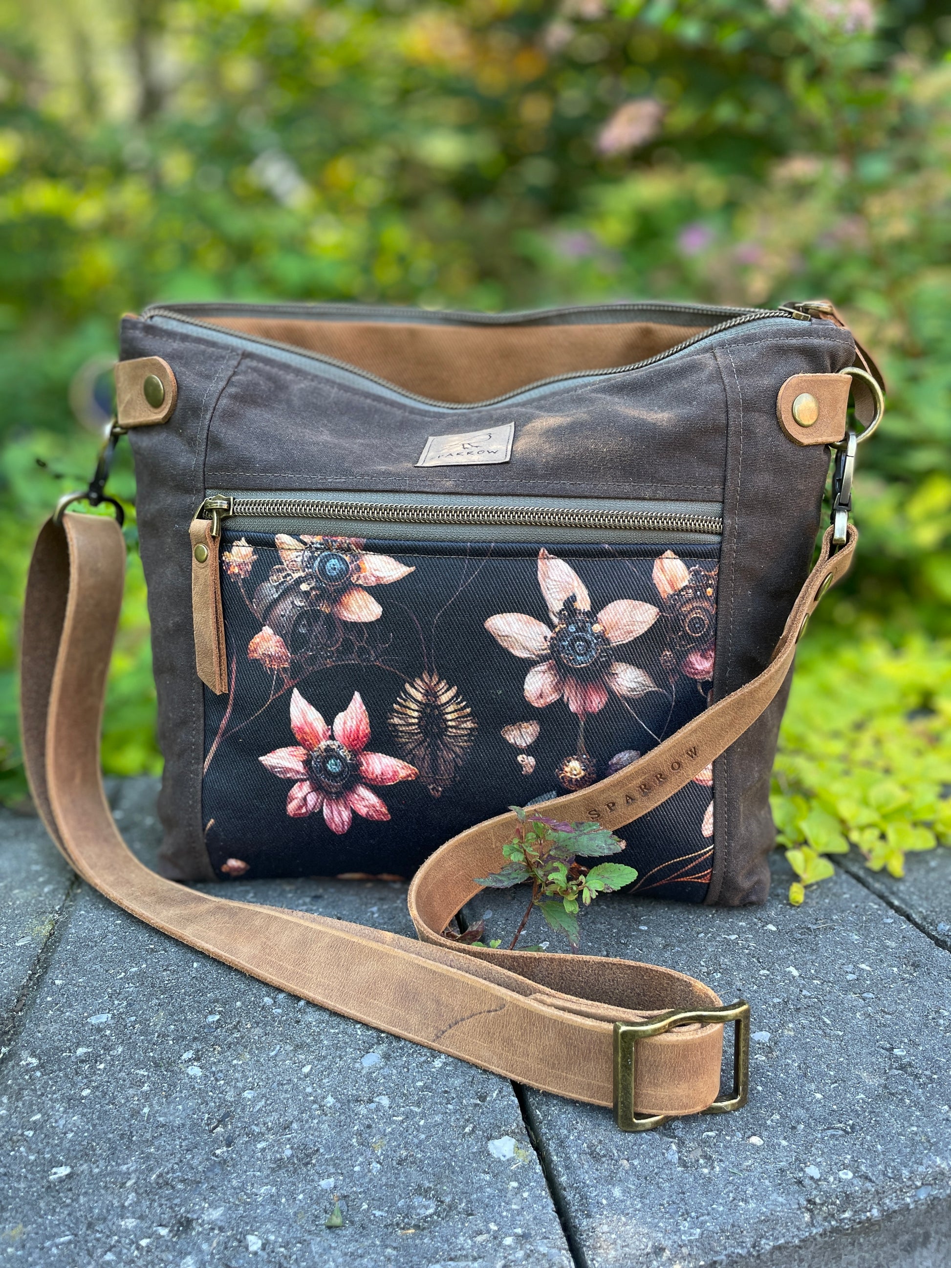 Sparrow Handmade Cambridge bag in dark brown waxed canvas and Steampunk floral accent.Fully lined in cinnamon denim, with leather strap and closures. Handcrafted in Calgary Canada. 