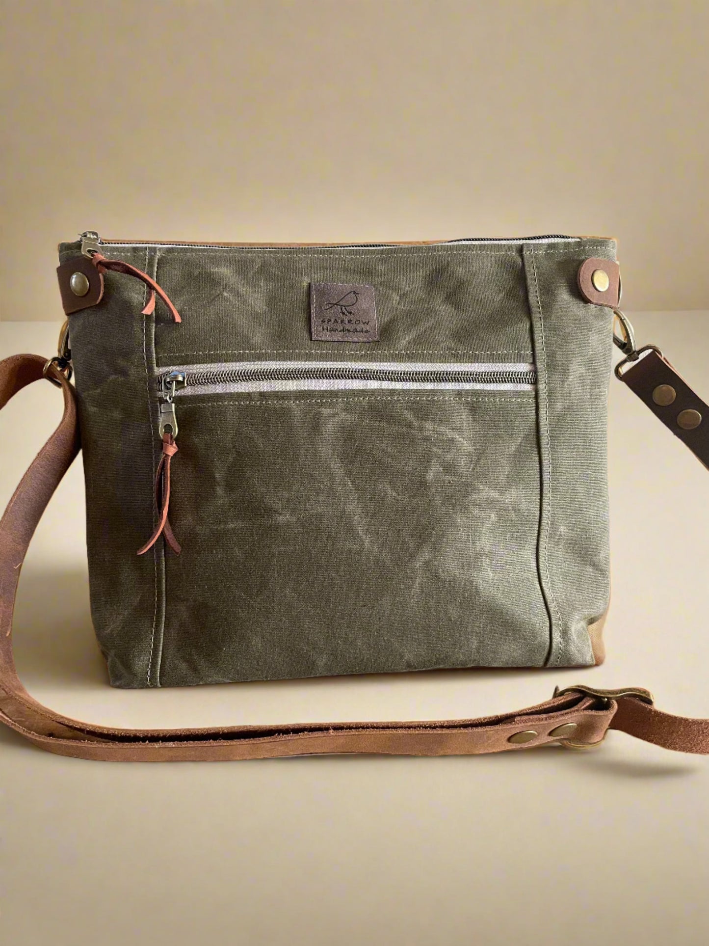 Cambridge crossbody bag in brown waxed canvas with zippered front pocket and top closure. Adjustable leather strap. Handcrafted in Canada by Sparrow Handmade.