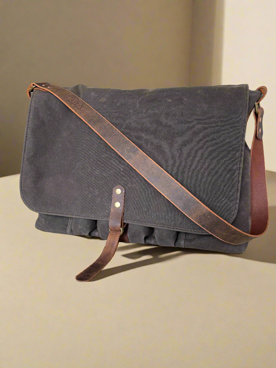 Attune crossbody bag in chocolate waxed canvas and olive green denim lining, for birthing stool. Leather strap, 4 leg pockets. 