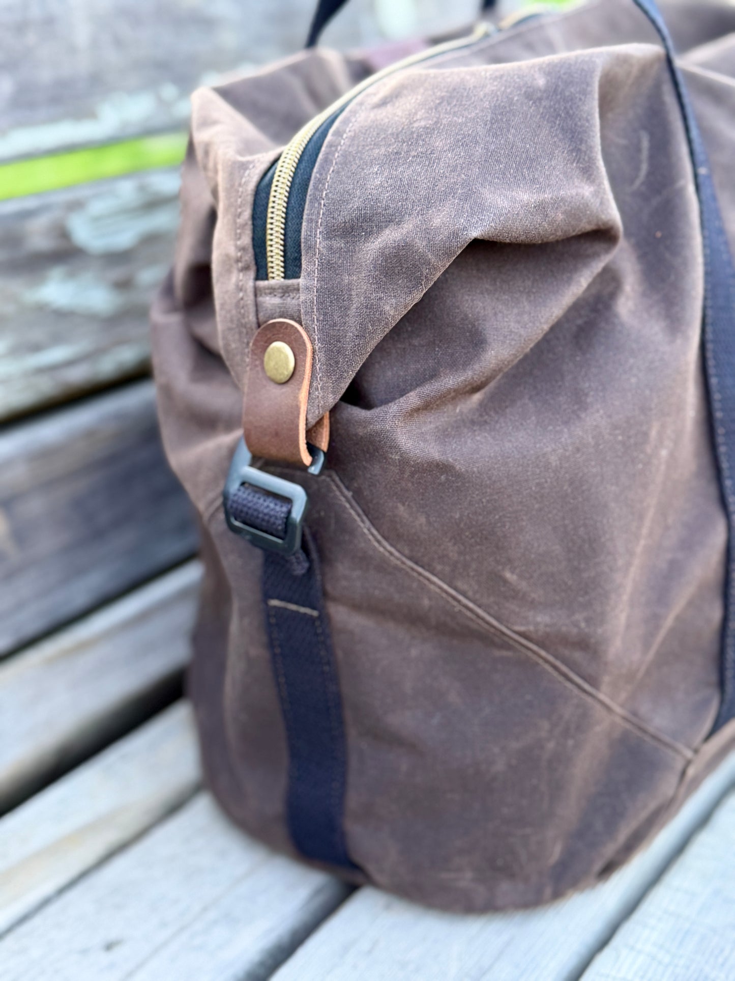 Brown waxed canvas Weekender duffel - side view showing hook to clamp down the top