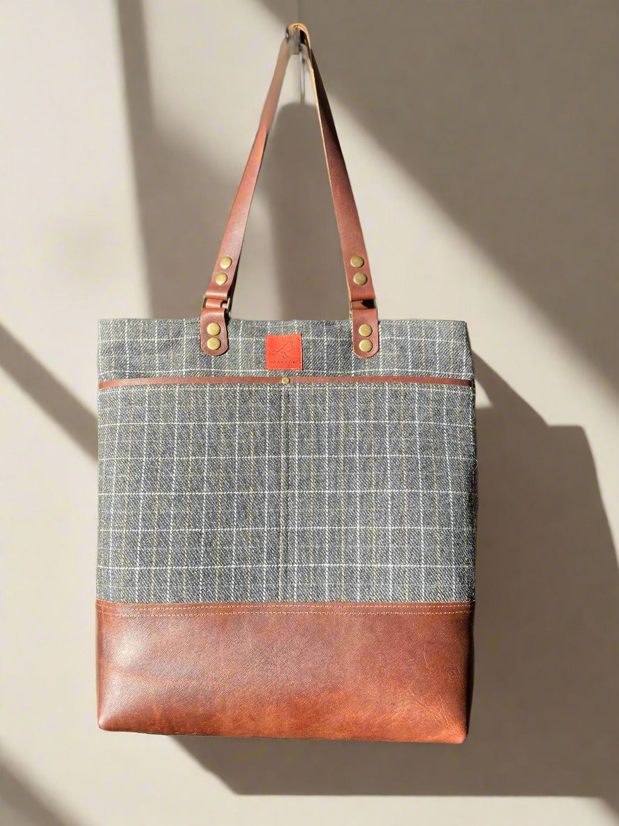 Classic tote bag with grey checkered wool upper, brown leather base and straps. Two front slip pockets, 1 back leather slip pocket, fully lined with slip pockets and zippered pocket inside. Very classic, timeless style. 