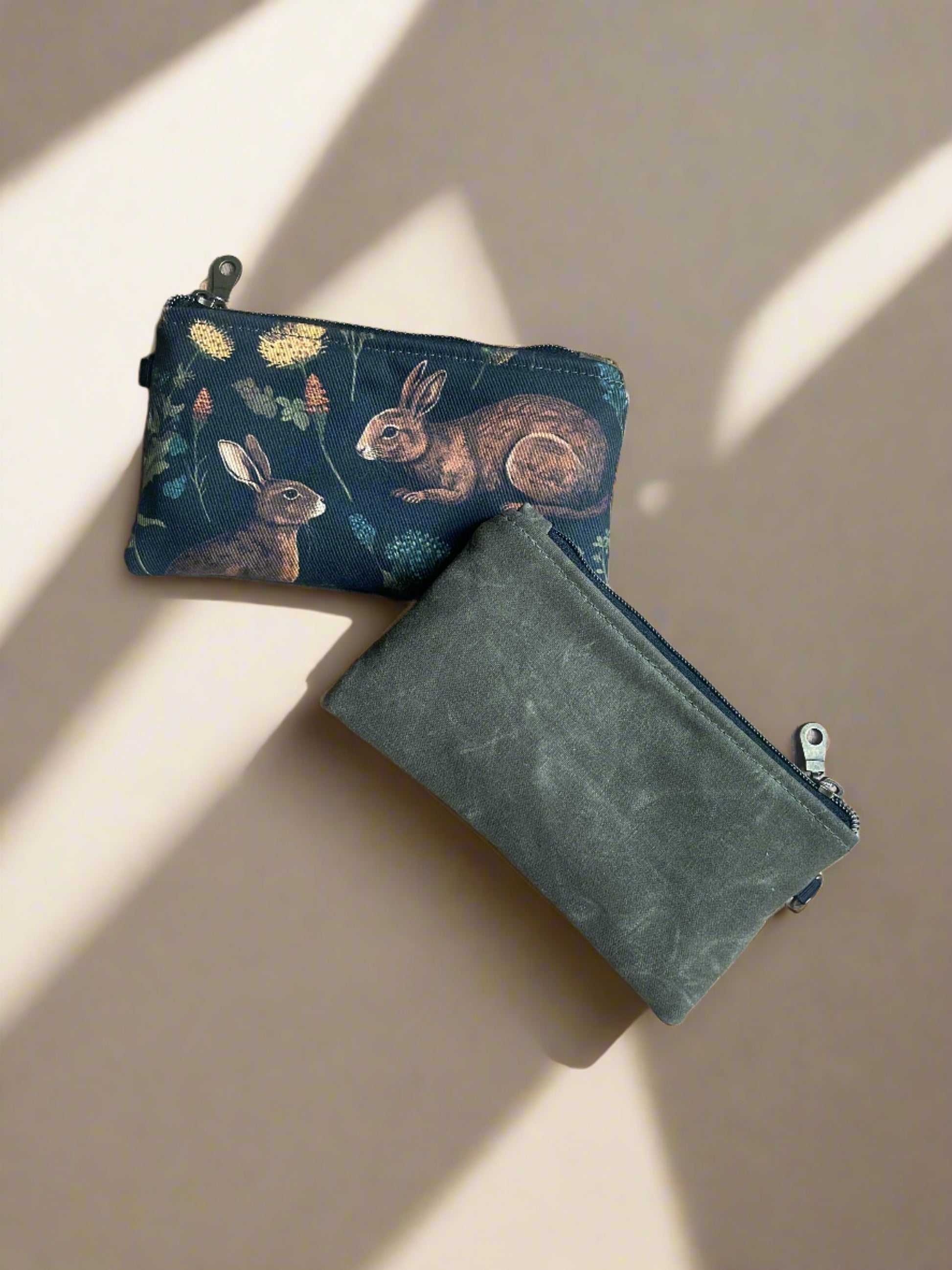 Zippered pouch in olive waxed canvas on the back and medieval rabbit print on the front. Handcrafted in Canada by Sparrow Handmade. 